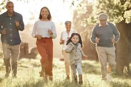 Family, running and parents or grandparents with girl child in park for freedom, adventure or playi