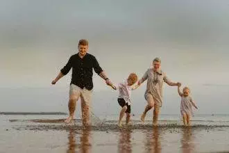 nice caucasian family having fun running in sea on sunset.Summer vacation with kids