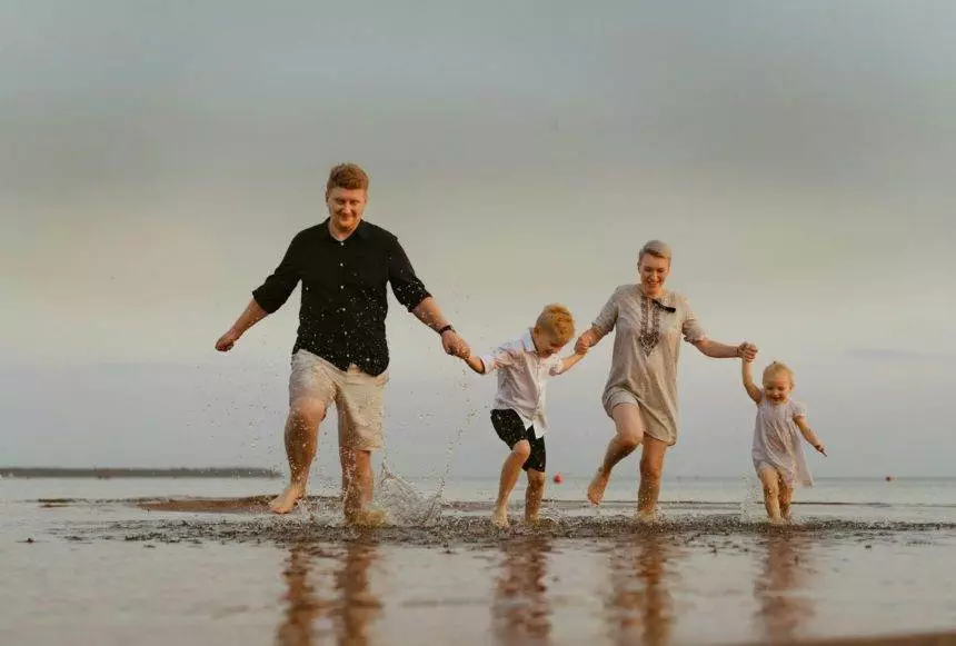 nice caucasian family having fun running in sea on sunset.Summer vacation with kids