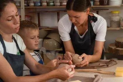 Adults and children in pottery school