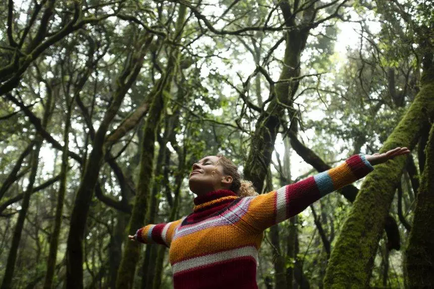 Freedom people enjoyng feeling with nature forest. Woman outstretching arms in the green