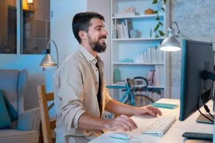 Young creative entrepreneur happy smiling while working in his modern workspace at home.